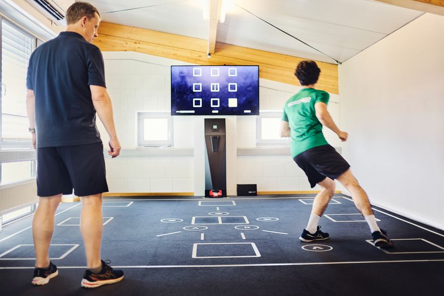 Therapeut leitet Sprint- und Reaktionstraining auf dem interaktiven Trainingsboden an