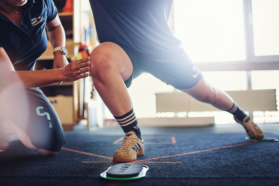 Gleichgewichtstraining mit Medizinball auf dem Balance-Pad